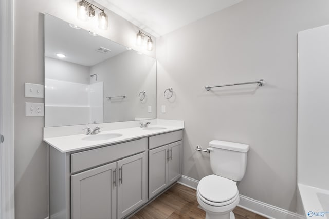 bathroom with hardwood / wood-style floors, vanity, and toilet