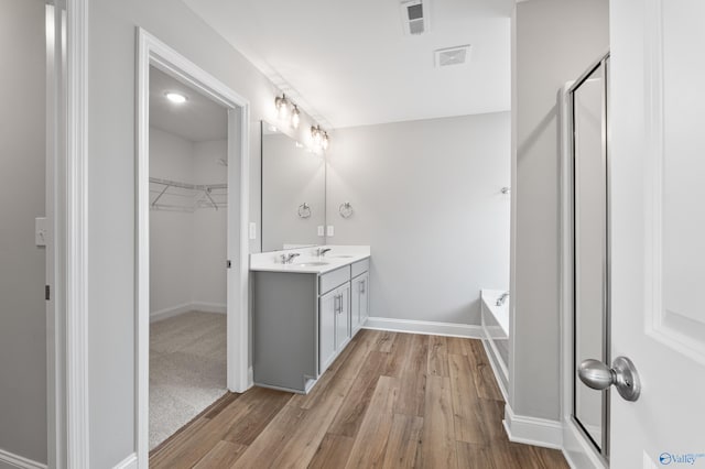 bathroom with vanity, hardwood / wood-style flooring, and independent shower and bath