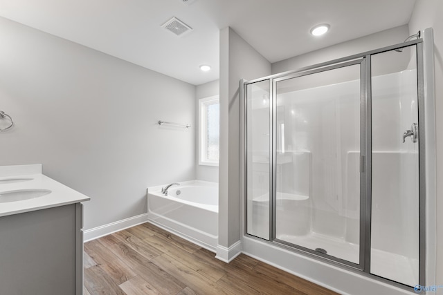 bathroom featuring vanity, independent shower and bath, and wood-type flooring