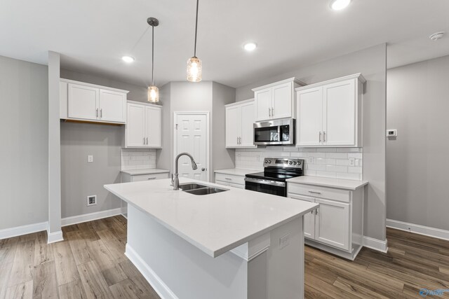 kitchen with dark brown cabinets, sink, stainless steel appliances, and an island with sink