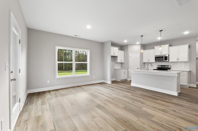 kitchen featuring backsplash, dark brown cabinetry, light stone counters, and appliances with stainless steel finishes