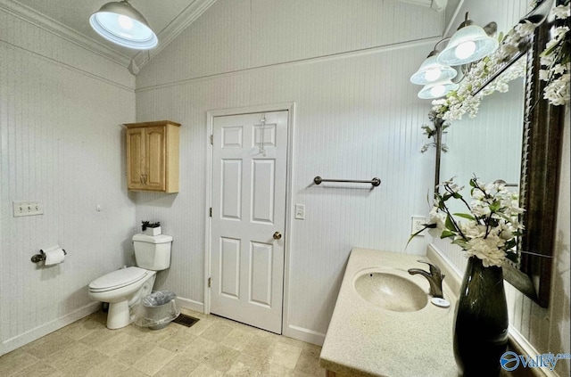 bathroom with vanity, toilet, crown molding, and lofted ceiling