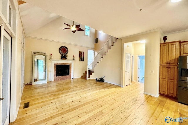 unfurnished living room featuring crown molding, light wood-type flooring, and ceiling fan