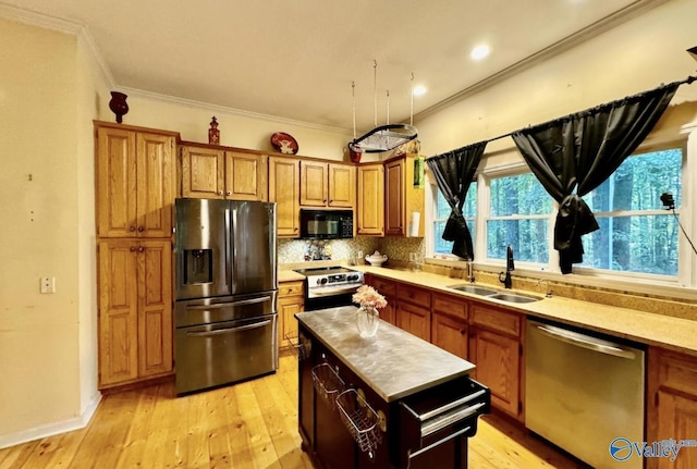 kitchen with sink, light wood-type flooring, decorative backsplash, and appliances with stainless steel finishes