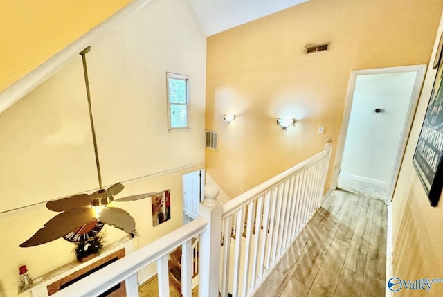 hall with wood-type flooring and lofted ceiling