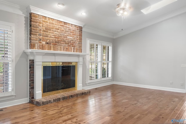 unfurnished living room featuring a fireplace, a wealth of natural light, hardwood / wood-style floors, and ceiling fan