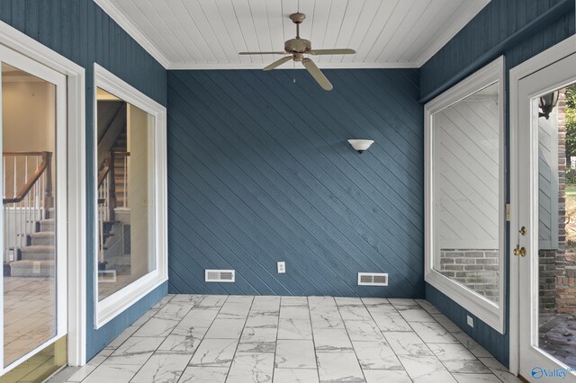 unfurnished sunroom with ceiling fan