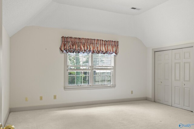 bonus room featuring vaulted ceiling and light colored carpet