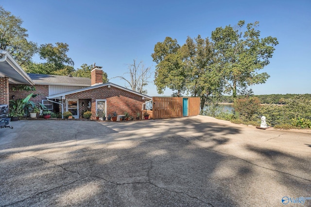 411 Darby Ave, Sheffield, AL 35660 - view of property exterior featuring brick siding, a chimney, and a gate
