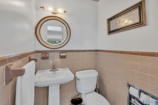 411 Darby Ave, Sheffield, AL 35660 - bathroom with a wainscoted wall, toilet, and tile walls