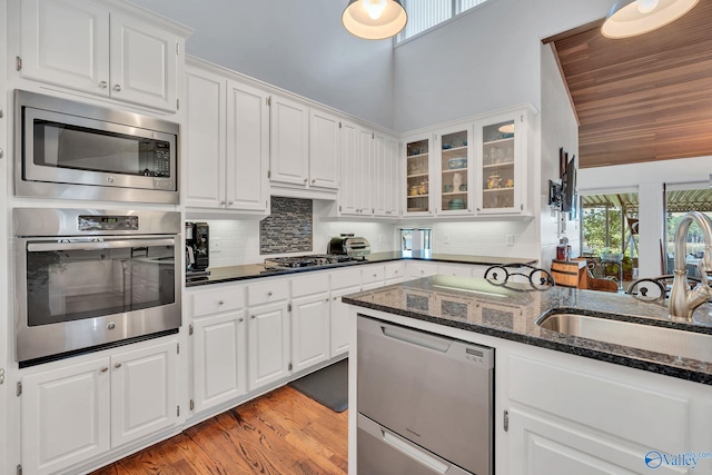 411 Darby Ave, Sheffield, AL 35660 - kitchen featuring decorative backsplash, white cabinets, a sink, and appliances with stainless steel finishes