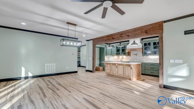 kitchen featuring light hardwood / wood-style flooring, tasteful backsplash, pendant lighting, a kitchen island, and ceiling fan