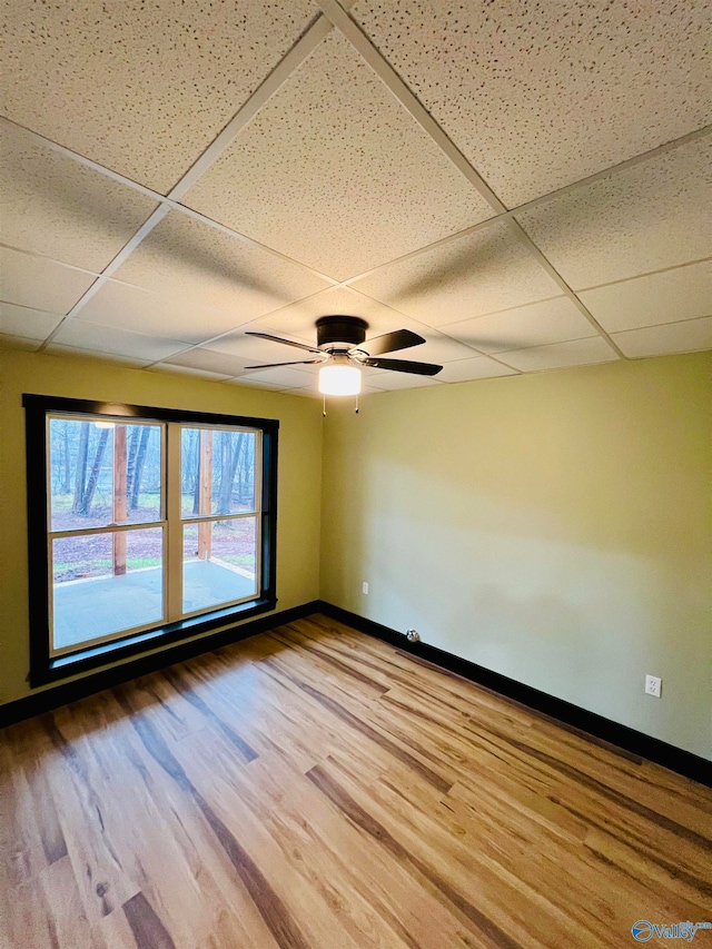 spare room featuring a paneled ceiling, ceiling fan, and wood-type flooring