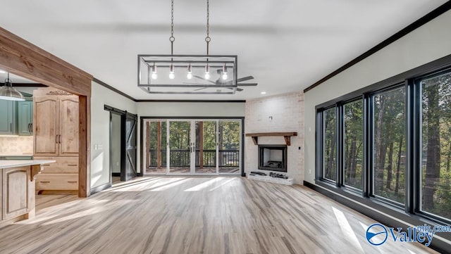 unfurnished living room with brick wall, a fireplace, ceiling fan, and light hardwood / wood-style floors