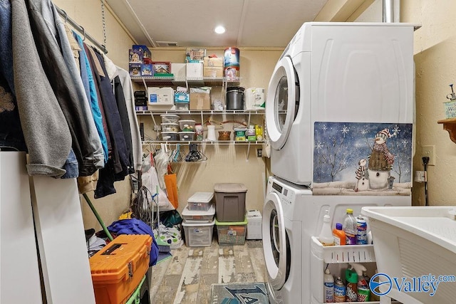 laundry area featuring hardwood / wood-style floors and stacked washer / dryer