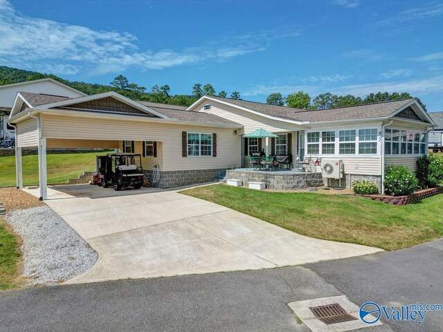 view of front of house with a yard, a carport, and ac unit