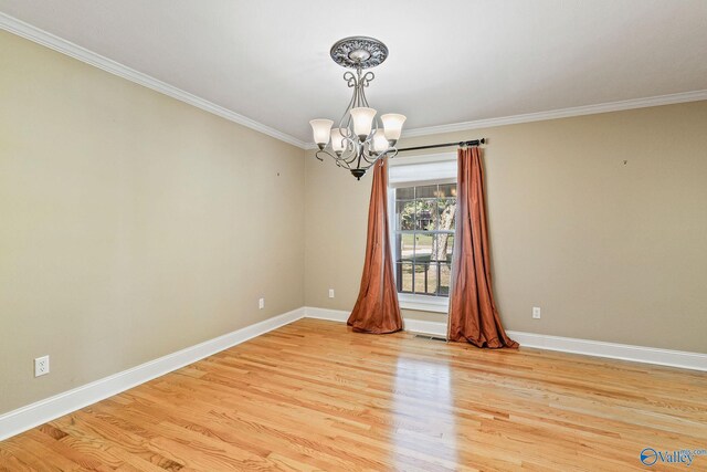 unfurnished room featuring a chandelier, ornamental molding, and light wood-type flooring