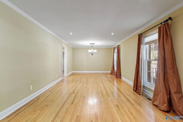 unfurnished room featuring crown molding, light hardwood / wood-style floors, and a chandelier