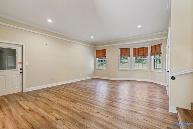 unfurnished room featuring ornamental molding and light wood-type flooring