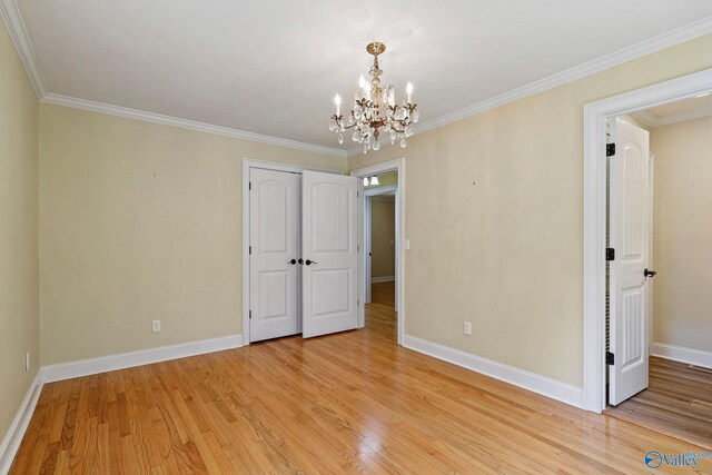 interior space with light hardwood / wood-style flooring, crown molding, and a chandelier