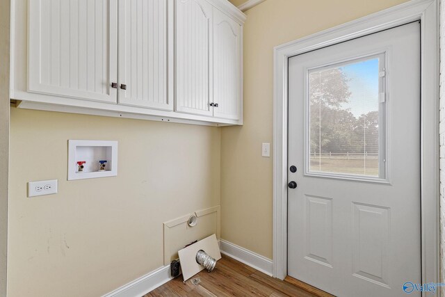 laundry area featuring plenty of natural light, hardwood / wood-style flooring, cabinets, and hookup for an electric dryer