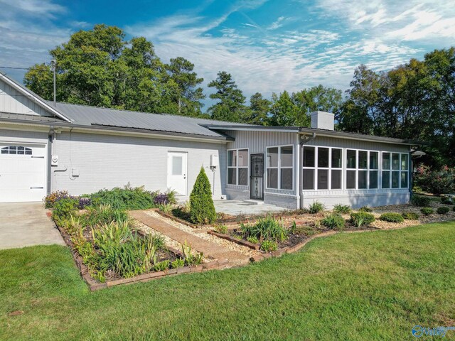 single story home featuring a sunroom and a front yard