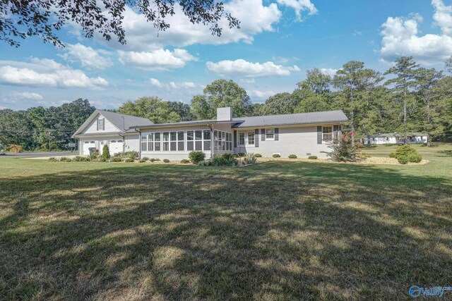 ranch-style home with a sunroom and a front yard