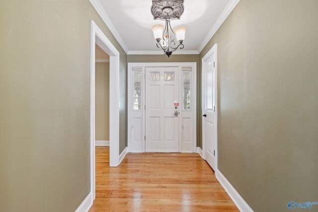 foyer featuring an inviting chandelier, light hardwood / wood-style flooring, and ornamental molding