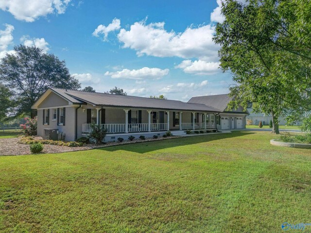 ranch-style house with a garage, a front lawn, cooling unit, and a porch