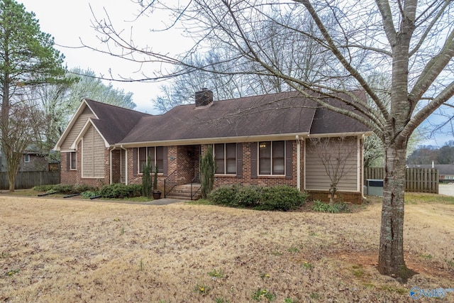 single story home featuring brick siding, a chimney, and fence