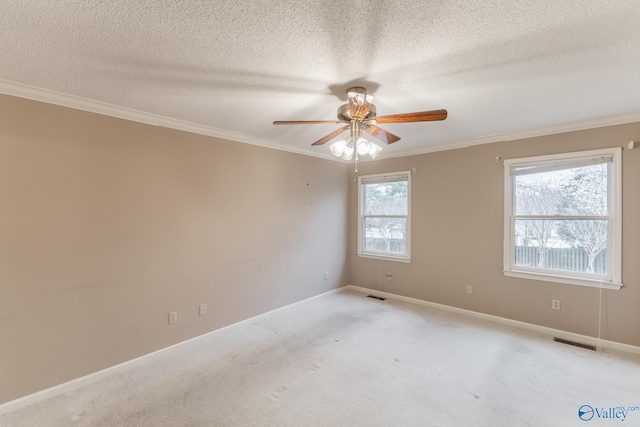 unfurnished room with visible vents, a healthy amount of sunlight, and a ceiling fan