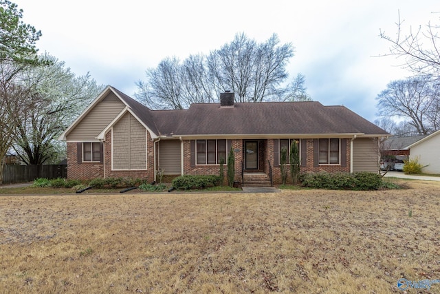 ranch-style home featuring a front lawn, brick siding, a chimney, and fence