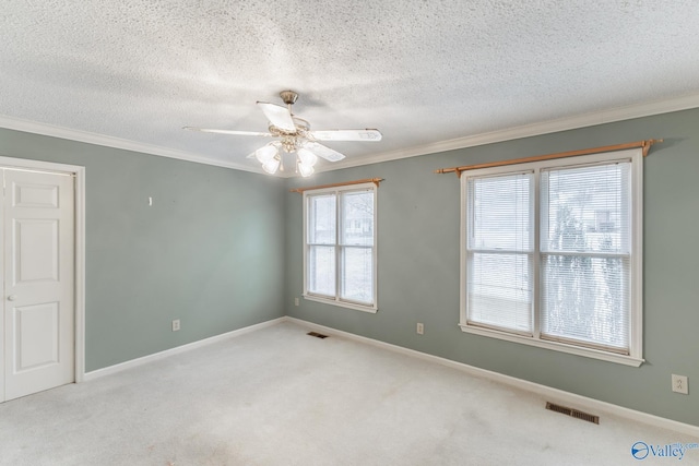 empty room with visible vents, crown molding, and carpet floors