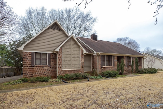 ranch-style home featuring a front lawn, brick siding, and a chimney