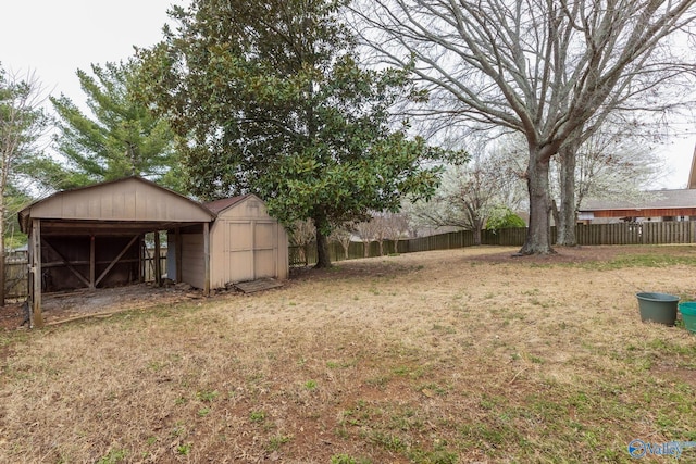 view of yard featuring a shed, an outdoor structure, and fence