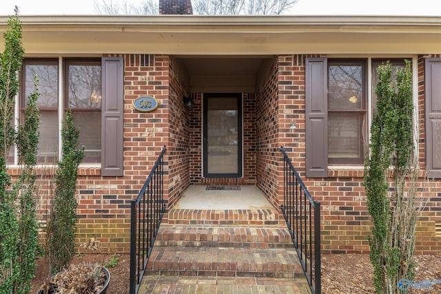 doorway to property featuring brick siding