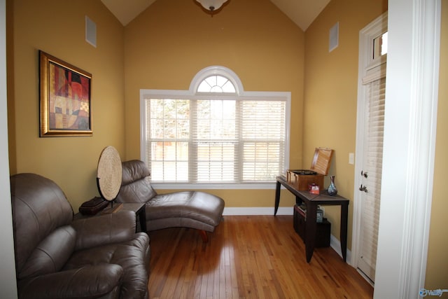 sitting room with lofted ceiling and light wood-type flooring