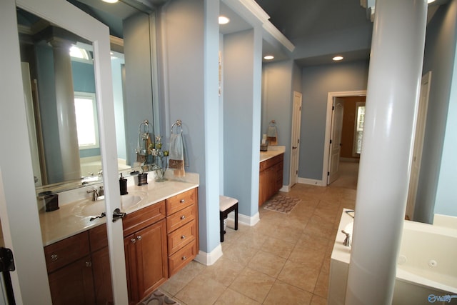 bathroom featuring tile patterned flooring, vanity, a bathing tub, and decorative columns