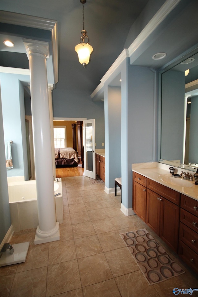 bathroom with vanity, a tub to relax in, tile patterned flooring, and ornate columns