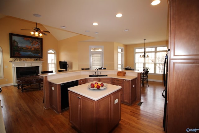 kitchen featuring a kitchen island, black dishwasher, sink, and kitchen peninsula