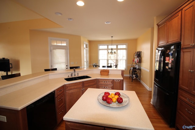 kitchen featuring a center island, sink, dark hardwood / wood-style flooring, and black appliances