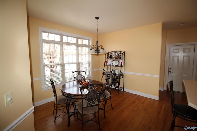 dining area with a notable chandelier and dark hardwood / wood-style flooring