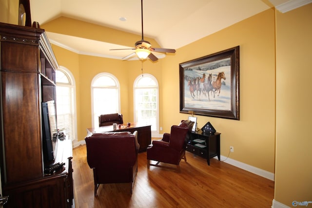 living area with vaulted ceiling, crown molding, hardwood / wood-style floors, and ceiling fan