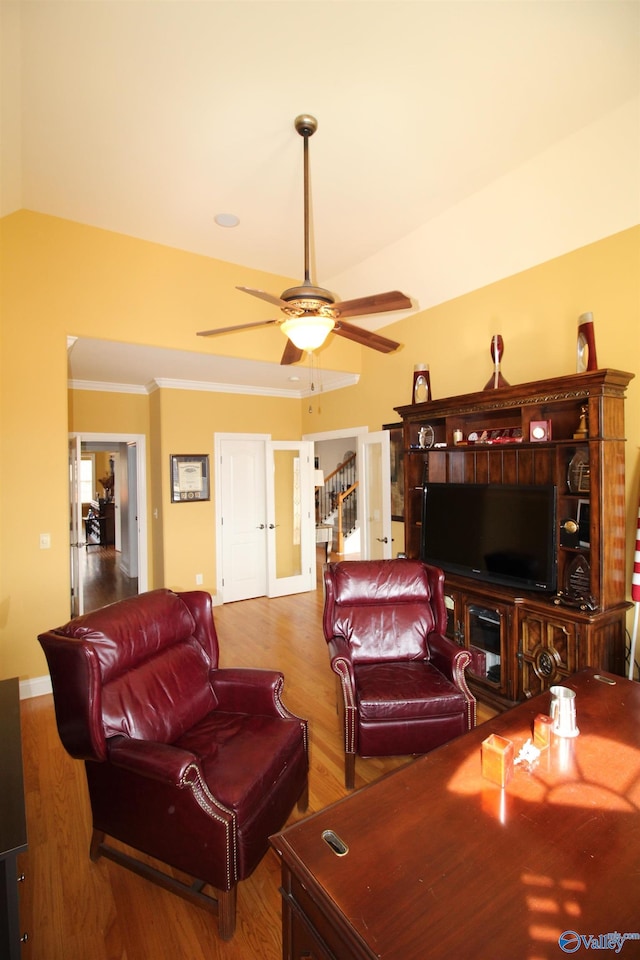 living room featuring hardwood / wood-style flooring, ornamental molding, lofted ceiling, and ceiling fan