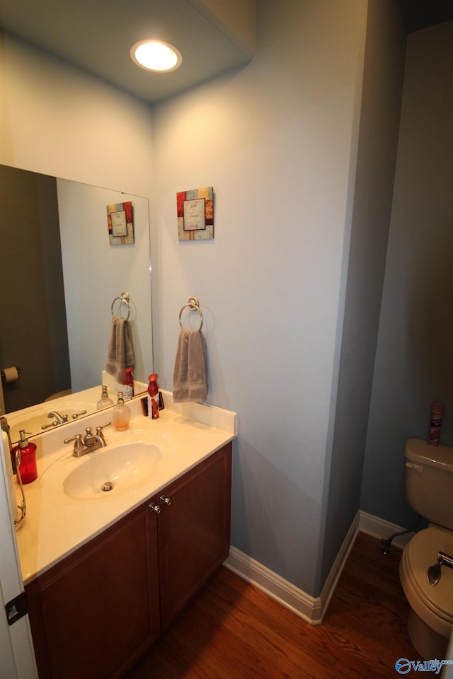 bathroom with hardwood / wood-style flooring, vanity, and toilet