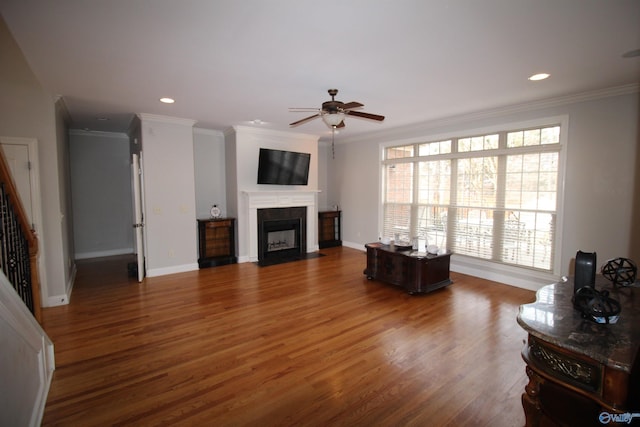 living room featuring ceiling fan, ornamental molding, and wood-type flooring