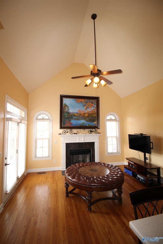 living room featuring ceiling fan, wood-type flooring, and vaulted ceiling