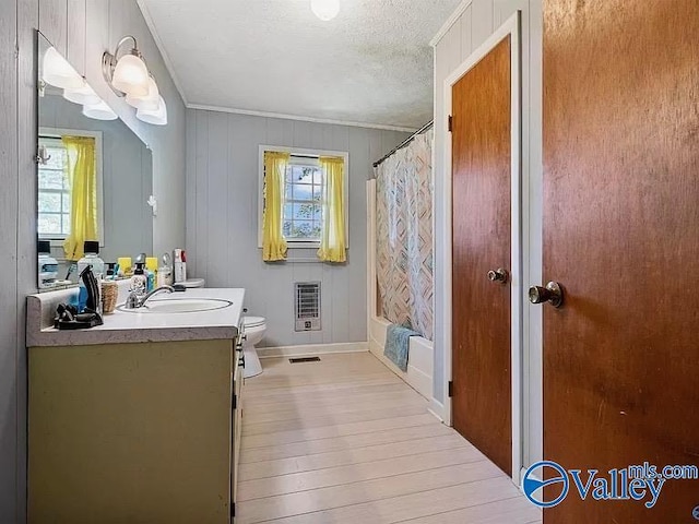 full bathroom featuring toilet, wood-type flooring, a textured ceiling, vanity, and shower / bath combination with curtain