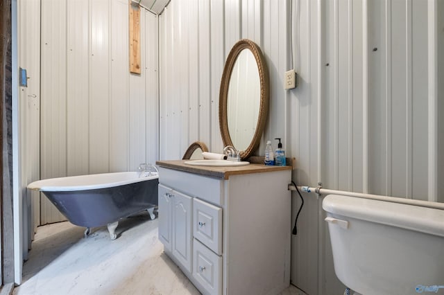 bathroom featuring vanity, toilet, and a tub