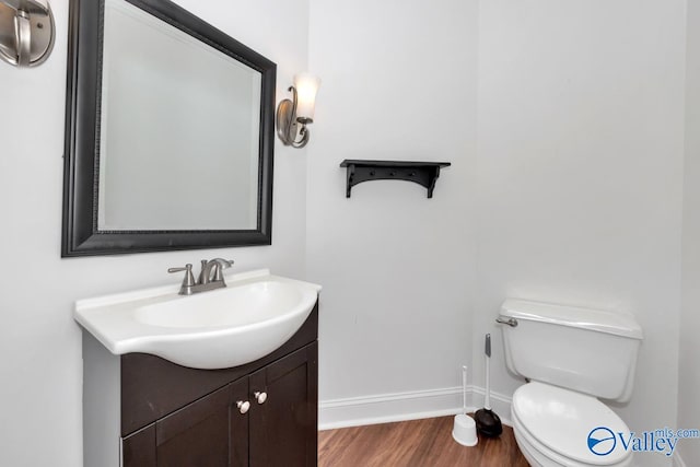 bathroom featuring vanity, wood-type flooring, and toilet